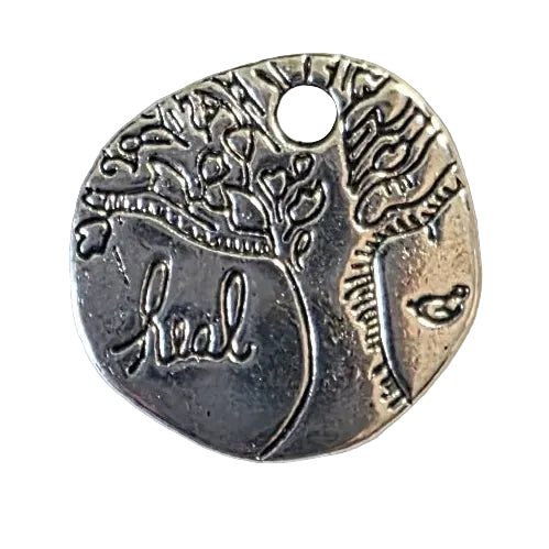 Small silver pendant with engraved design of Tree of Life and the word "heal" on a light gray background