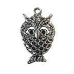 Silver owl shaped charm on a light gray background
