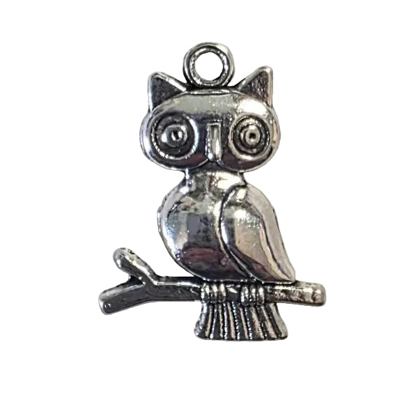 Silver owl on twig charm on a light gray background