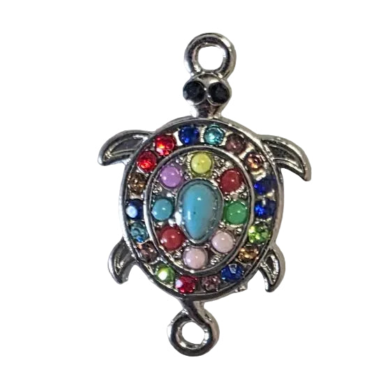 Tortoise-shaped charm with colorful stones on a gray background